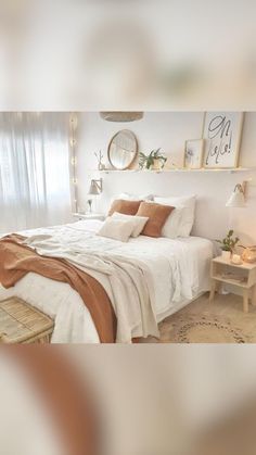 a bedroom with white walls and wooden flooring is decorated in neutral colors, including beiges and browns