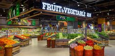 the produce section of a grocery store with fruits and vegetables on display in large baskets