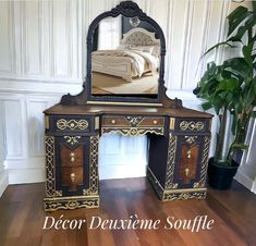 an ornate desk with a mirror on top of it next to a potted plant