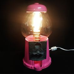 a pink gummy machine with a light on it's top and a cord attached to the front