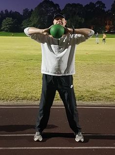 a man holding a green ball over his head