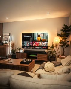 a living room filled with furniture and a flat screen tv on top of a wooden table