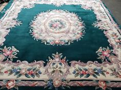 a large green rug with floral designs on it