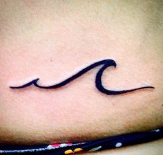 a woman's stomach with a wave tattoo on the side of her belly, which is drawn in black ink