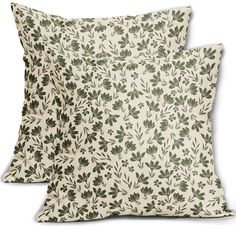 two pillows with green leaves on them, one in white and the other in black