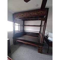 an old wooden bunk bed in the corner of a room with carpeted flooring