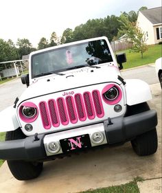 a pink and white jeep parked in front of a house