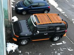 two cars parked on the side of a road covered in snow next to each other