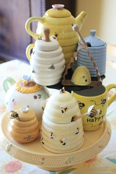 there are many teapots and mugs on the table with honeycombs