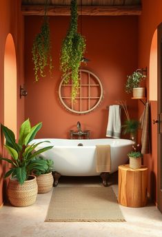 a bathtub with plants hanging from it's sides in an orange walled bathroom