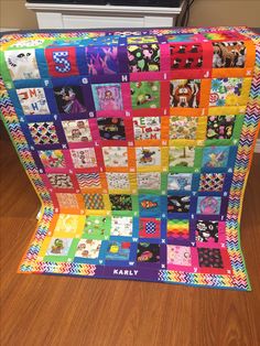 a multicolored quilt is displayed on the floor