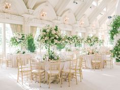 the tables are set with white flowers and greenery