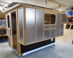 the inside of a portable home being built in a garage with wood and metal panels