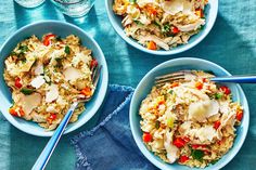 three bowls filled with rice and vegetables on top of a blue cloth next to silverware