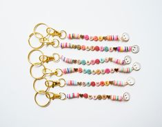 six key chains with different colors and designs on them, all lined up in a row