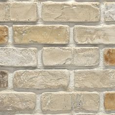 an old brick wall with white and brown bricks