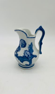 a small blue and white pitcher sitting on top of a table