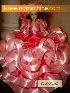 the doll is wearing a pink and red dress with roses on it's skirt