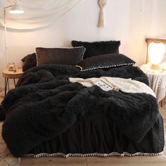 a bed with black comforter and pillows on it