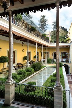 an outdoor courtyard with columns and potted plants