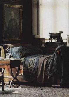 a bedroom with a bed, chair and painting on the wall next to a window