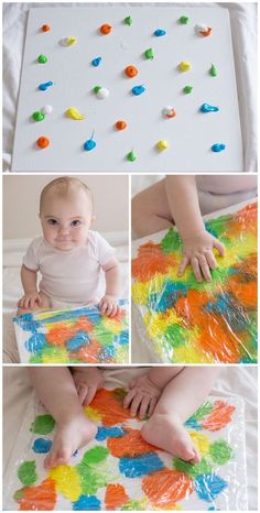 the baby is playing with his colorful art project on the floor, and then making it look like he's getting ready to paint