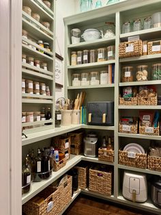 an organized pantry with lots of shelves and wicker baskets on the bottom shelfs