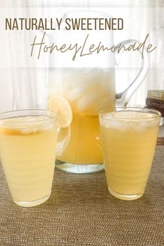 two glasses of honey lemonade sit next to a pitcher and jug with the words, naturally sweetened honey lemonade