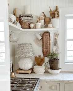 a kitchen filled with lots of dishes and cooking utensils on top of shelves