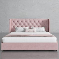 a pink bed with white sheets and pillows in a gray room next to a wall