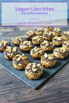 vegan lion bites with chocolate and nuts on a black plate next to the ocean