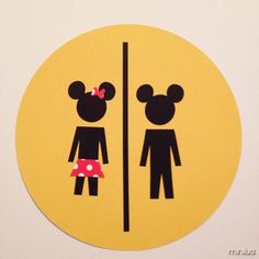 a yellow and black sticker depicting two people standing in front of a mirror with minnie mouse ears on it