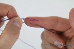 two hands are working on some type of thread