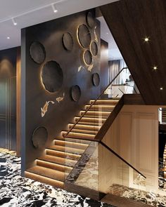 the stairs are made of wood and have metal circles on them, along with marble flooring