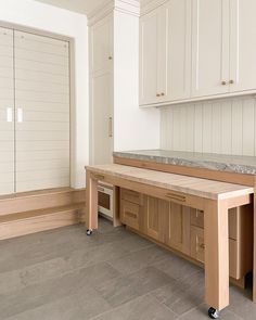 an empty kitchen with white cabinets and marble counter tops on casteors in the center