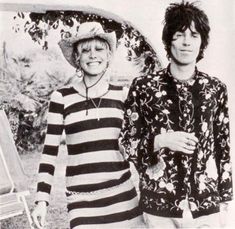 two people standing next to each other in black and white