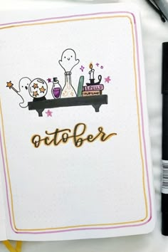 an open notebook with the word october written in gold on it and two ghost characters