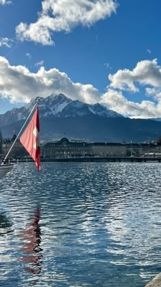 a boat floating on top of a lake next to a mountain