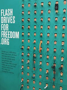 a wall with many heads on it that says flash drives for freedom origg