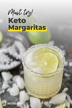 the margarita is garnished with limes and sugar on the rocks next to it