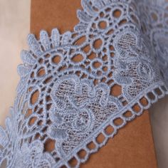 a piece of brown paper with blue lace on it