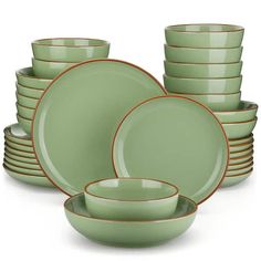 a stack of green dishes with gold rims on top of each plate and bowl