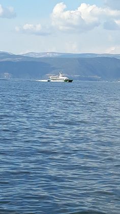 a boat is in the water with mountains in the background