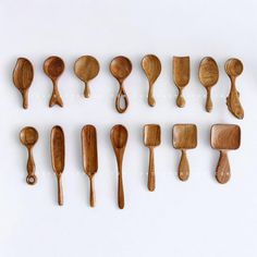 wooden spoons and spatulas lined up on a white surface