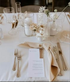 the table is set with silverware, flowers and napkins for an elegant wedding reception