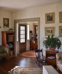 a living room filled with furniture and pictures on the wall above it's doorway