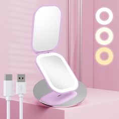 an electronic device that is charging on a pink surface with two circles around it and the light reflecting in the mirror