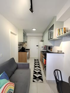 a living room filled with furniture next to a kitchen