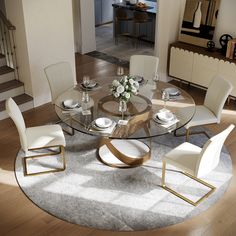 a round glass table with white chairs and plates on it in a living room area