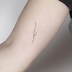 a woman's arm with a single flower tattoo on the back of her left arm